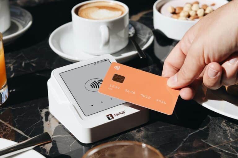 A person holding a credit card over a table