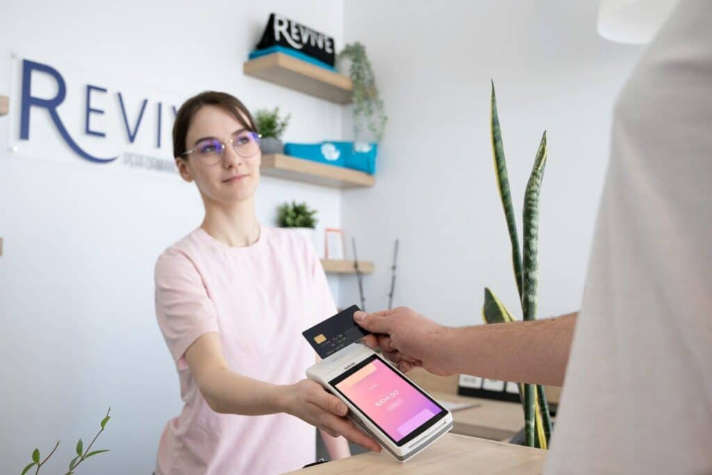 a woman is handing a card to a man