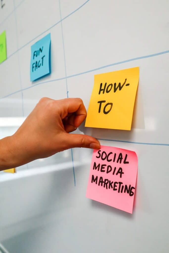 a hand is pointing to sticky notes on a bulletin board